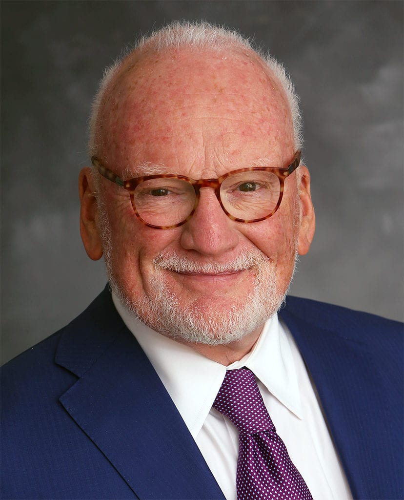 A headshot of Richard A Clarke wearing a blue blazer and a white shirt with a red and blue tie